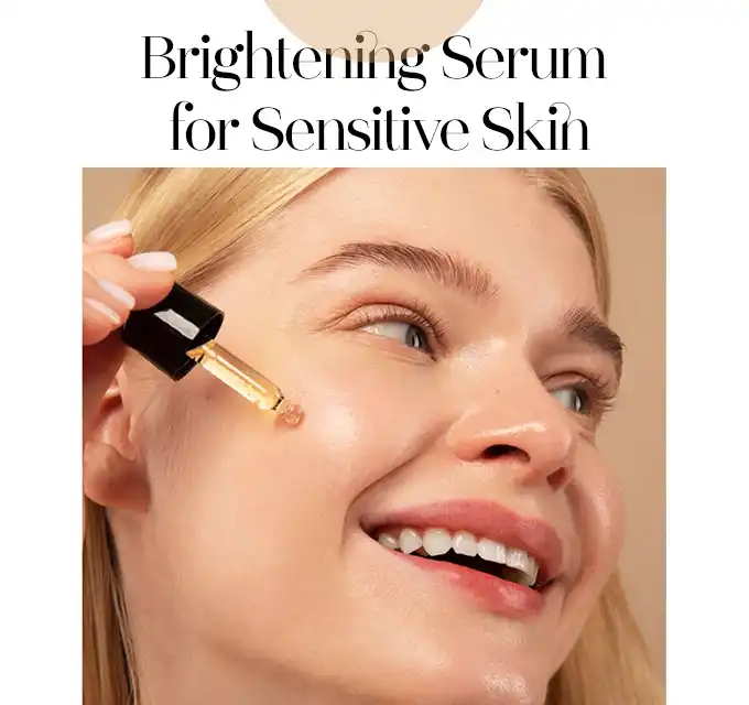 Smiling young woman holding a dropper near her cheek applying a light golden vitamin C serum, skin appears smooth and luminous